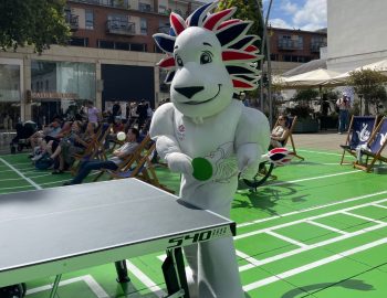 The British Olympic mascot plays table tennis as the crowd in the background watch the big screen