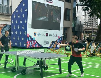 Table Tennis Players play in front of a big screen