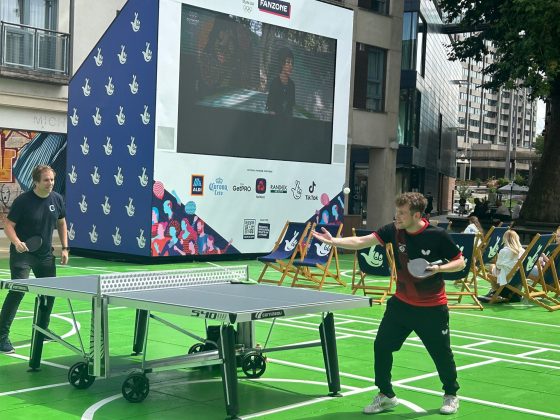 Table Tennis Players play in front of a big screen